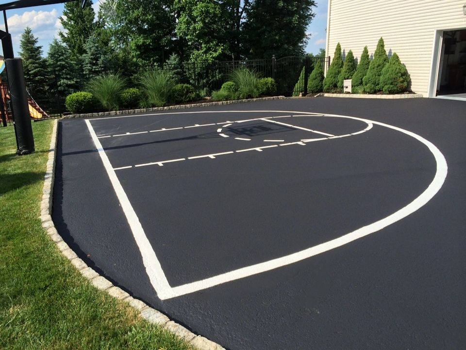 Residential basketball court with professional line markings on asphalt