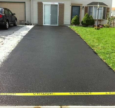 Newly paved residential driveway with caution tape